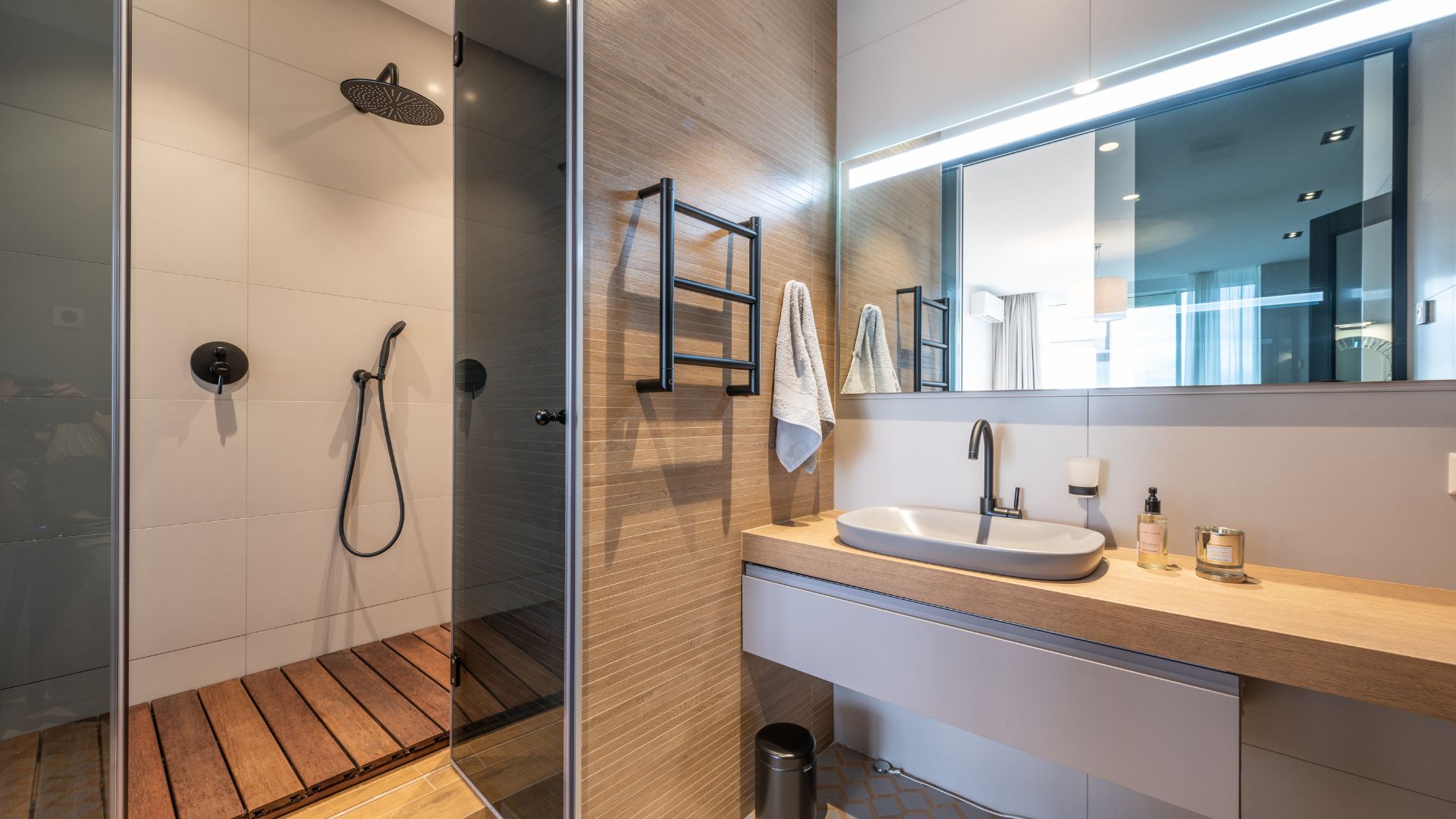 A bathroom with a shower, sink and mirror