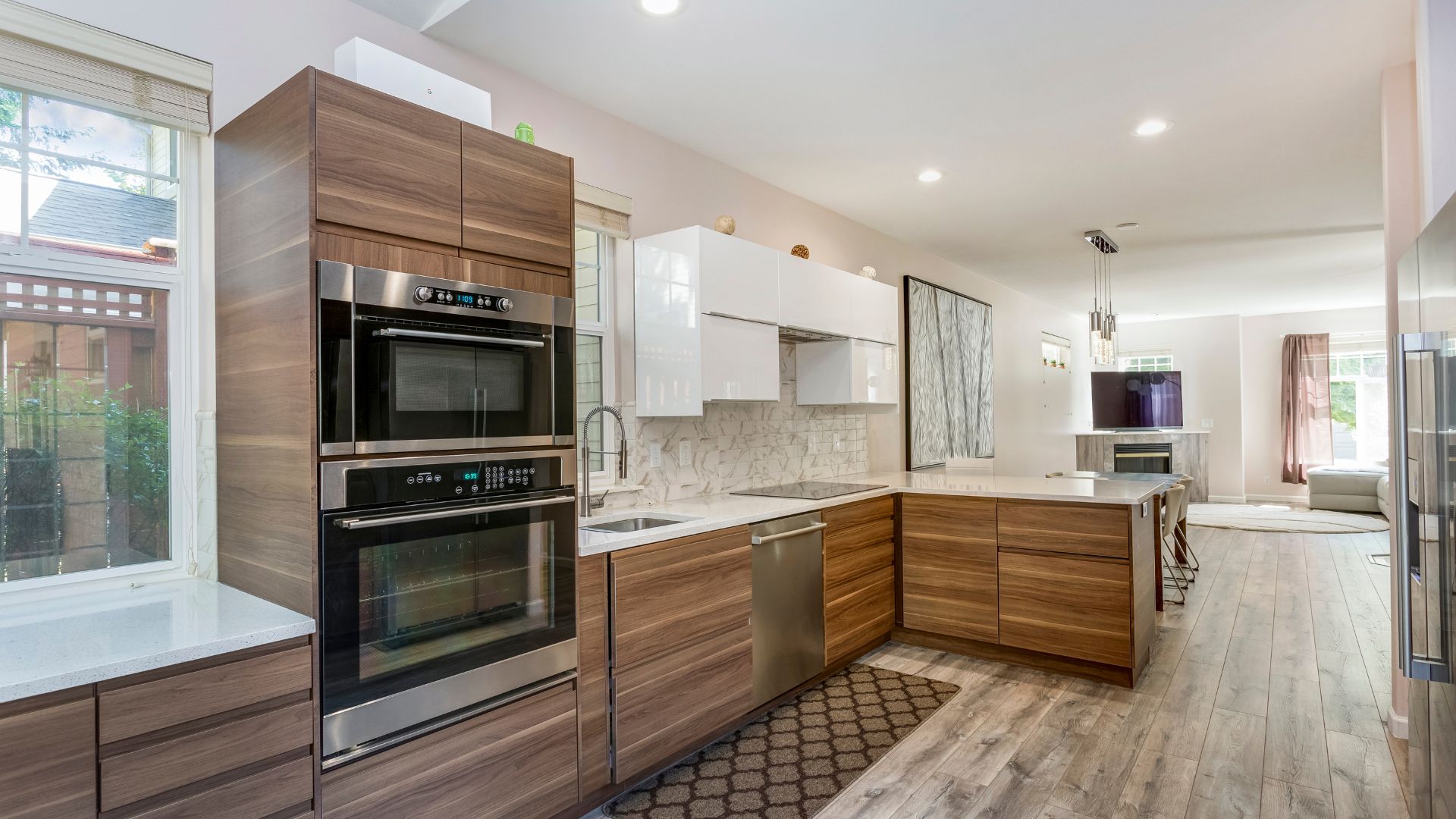 A kitchen with a stove, oven, sink and a window